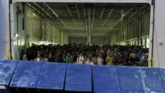 Syrští uprchlíci se chystají vyjít na pevninu v řeckém přístavu Pireus.
