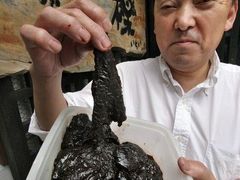 Shuji Ichihara, majitel restaurace v malém japonském městě Wada jižně od Tokia, ukazuje místní pochoutku - syrové velrybí maso.