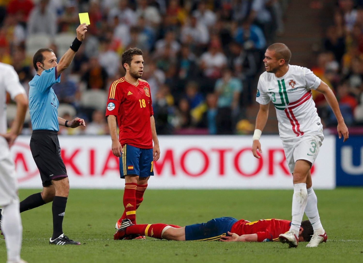 Turecký rozhodčí Cuneyt Cakir dává žlutou kartu Portugalci Pepemu během semifinálového utkání mezi Portugalskem a Španělskem na Euru 2012.