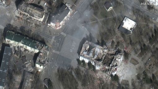 Vybombardované divadlo v Mariupolu na satelitním snímku. Před ním je na dlažbě stále čitelný nápis "děti".