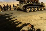 ZAČÁTKY - Afghánští bojovníci projíždějí na tanku T-62 kolem mrtvých těl. Snímek byl pořízen na silnici 3 km severně od Kábulu. 13. listopad 2001.