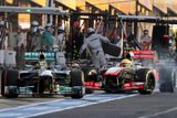 Nico Rosberg (vlevo) v boxech málem "sundal" McLaren Sergia Pérez. Za to dostal pilot Mercedesu trest průjezdu boxy.
