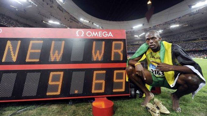 Usain Bolt pózuje u tabule s hodnotou nového světového rekordu.