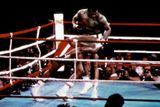 Jeden z nejslavnějších zápasů boxerské historie, který vstoupil do dějin pod názvem The Rumble in the Jungle (Rachot v džungli), se odehrál 30. října 1974 v Kinshase. Muhammad Alimu, který nastoupil proti obávanému a mladšímu, dosud neporaženému šampionu Georgi Foremanovi, skoro nikdo nedával šanci na úspěch. Ali však vsadil na defenzivní pojetí a namísto svého obvyklého tanečního stylu se stále opíral o provazy a snažil se krýt soupeřovy útoky. Jeho plán nechat Foremana utahat se údery, které neměly větší efekt, Alimu vyšel. Soupeře knokautoval v osmém kole, čímž si vydobyl znovu titul největšího boxerského šampiona.