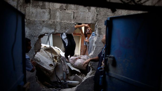 Palestinci prohlížejí svůj zničený dům v Pásmu Gazy.