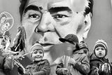 Leonid Iljič Brežněv na transparentu v prvomájovém průvodu roku 1979. Brežněv byl generálním tajemníkem Ústředního výboru Komunistické strany Sovětského svazu  (1966-1982) a předsedou prezídia Nejvyššího sovětu (1977-1982). Brežněvova doktrína omezené suverenity řídila sovětskou zahraniční politiku od roku 1968 až do Gorbačovovy perestrojky. Podle ní měl Sovětský svaz právo ovlivňovat i s použitím síly vývoj v libovolné zemi východního bloku, pokud zde hrozilo odvrácení od socialismu ke kapitalismu. Konkrétním příkladem její aplikace byla okupace Československa v srpnu 1968.