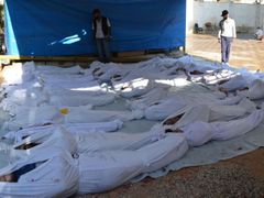 Syrský aktivista nad těly lidí, kteří podle tvrzení opozice zemřeli při chemickém útoku na damašské předměstí Ghúta. (21. srpna 2013)