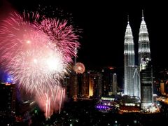 Petardy ozařují věže Petronas Twin Towers v malajsijském Kuala Lumpur. Nový rok sem přišel v našich pět hodin večer.