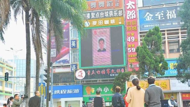 Dlužník na černém seznamu zobrazen na LED obrazovce v městě Taishan