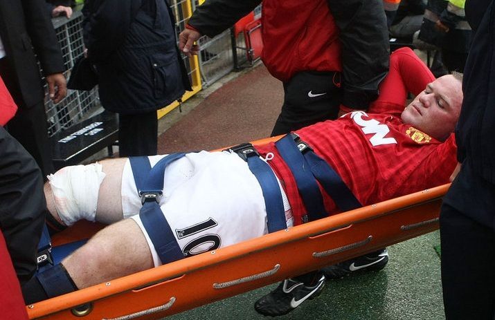 Zraněný Wayne Rooney opuští hřiště na stadionu Old Trafford