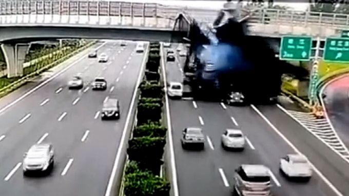 Bezpečnostní kamera zachytila nehodu u dálničního mostu v čínském Šanghaji. Náklaďák narazil do zábradlí, převrátil se a svrhnul asfalt na auta.