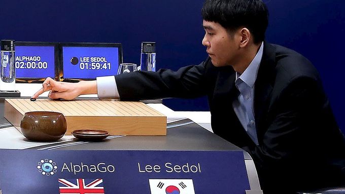 Světový šampion ve hře Go Lee Se-dol zahajuje partii proti umělé inteligenci, programu AlphaGo, respektive proti programátorovi Aja Huangovi.