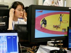 Reportérka se chystá na ostré vysílání. Čínská centrální televize připraví během dvou týdnů olympiády dva a půl tisíce hodin televizních přenosů ze sportovních utkání.