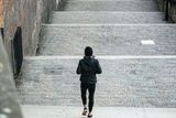 Jedna jediná žena běží po Zámeckých schodech z Pražského hradu.