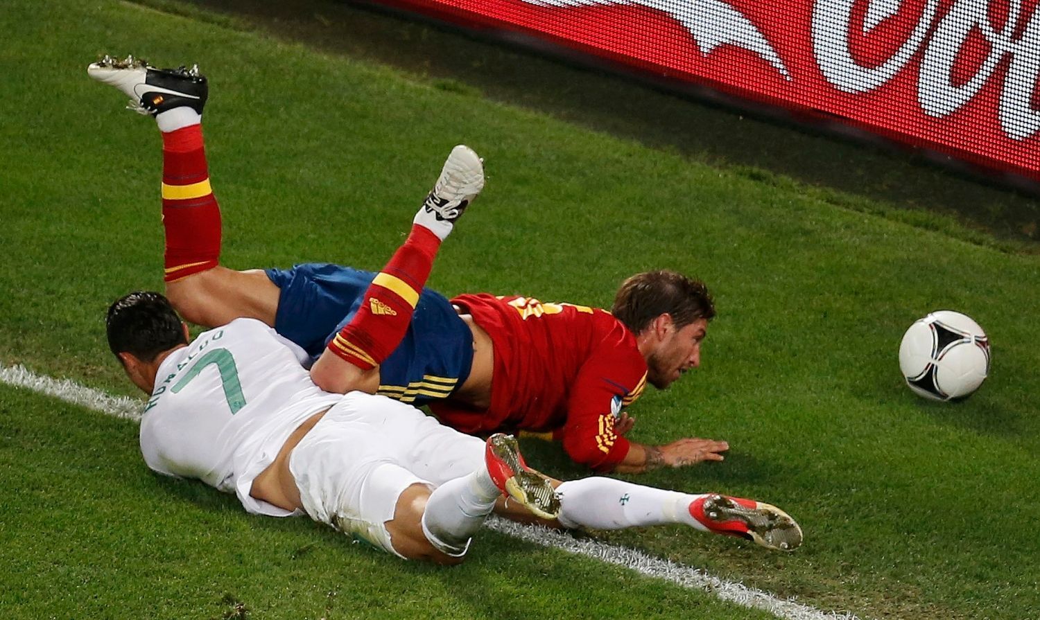 Sergio Ramos padá přes Cristiana Ronalda během semifinálového utkání mezi Portugalskem a Španělskem na Euru 2012.