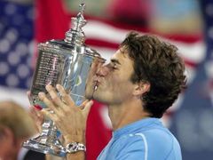 Švýcarský tenista Roger Federer s trofejí pro vítěze US Open, kterou získal potřetí za sebou.