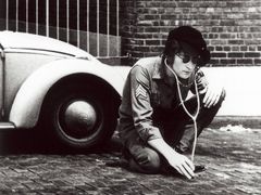 John Lennon a bílý VW Brouk.