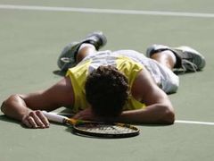 Kanadský tenista Frank Dancevic leží na kurtu během zápasu s Australanem Lleytonem Hewittem.