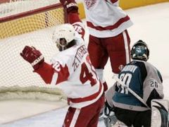 Brankář San José Jevgenij Nabokov (vpravo) se ohlíží do své branky, hráči Detroitu Red Wings Johan Franzen a Henrik Zetterberg už oslavují rozhodující gól v prodloužení.