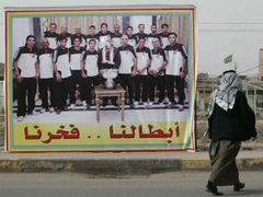 Billboard premiéra Malikího s iráckou fotbalovou reprezentací v Basře. Premiérovu tvář ovšem někdo "upravil" ostrým předmětem.