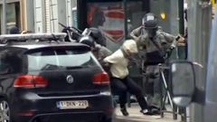 Belgická policie zatýká v Molenbeeku jednoho z trojice mužů. Snímek je pořízen z videozáznamu.
