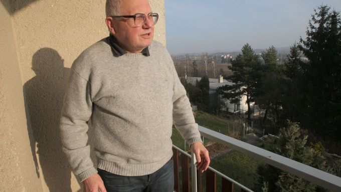 Jan Šantl na balkonu svého bytu. Jen pár set metrů za ním má stát Pražský okruh, o který se Praha pře s městskými částmi.