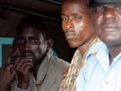 Policista hlídá zadržené piráty, kteří budou předání keňským úřadům, aby mohli být souzeni