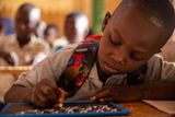 Děti netahají těžké školní brašny, na většinu předmětů si vystačí s malou tabulkou a křídou. Psaní a čtení ovládá dnes v zemi jen 36 procent dospělých. Úředním jazykem je tu francouzština.