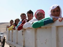 Jezídové přejíždějí v nákladních autobomilech do severovýchodní Sýrie, kterou ovládají místní Kurdové.