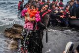 AKTUALITA: Filip Singer (EPA). Zoufalství - Lesbos, Řecko 2015: Uprchlíci se snaží dostat z přeplněného gumového člunu, který se málem rozbil o skaliska na pobřeží ostrova Lesbos, Řecko.