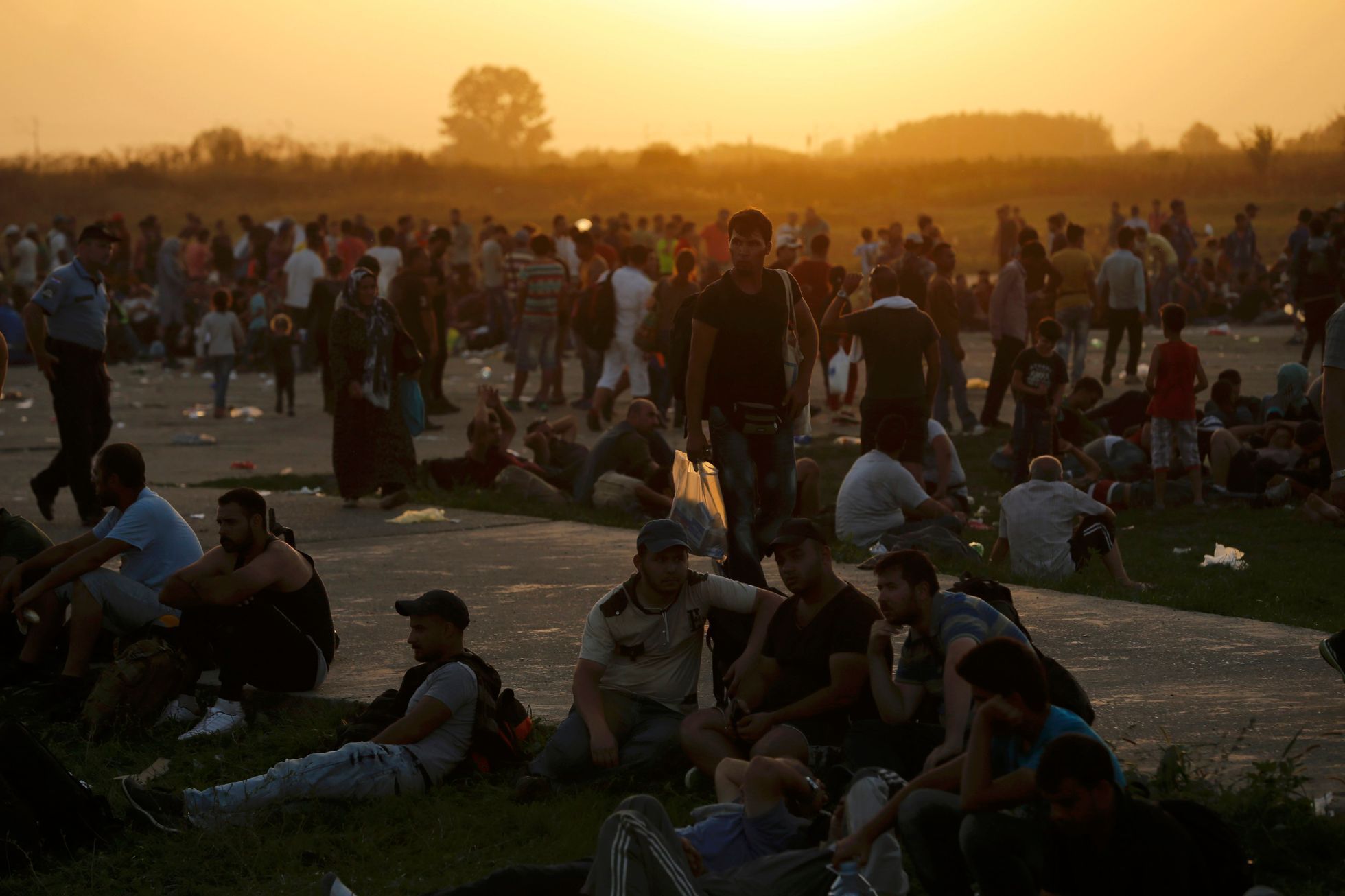 Migrants wait near the railway station in Tovarnik