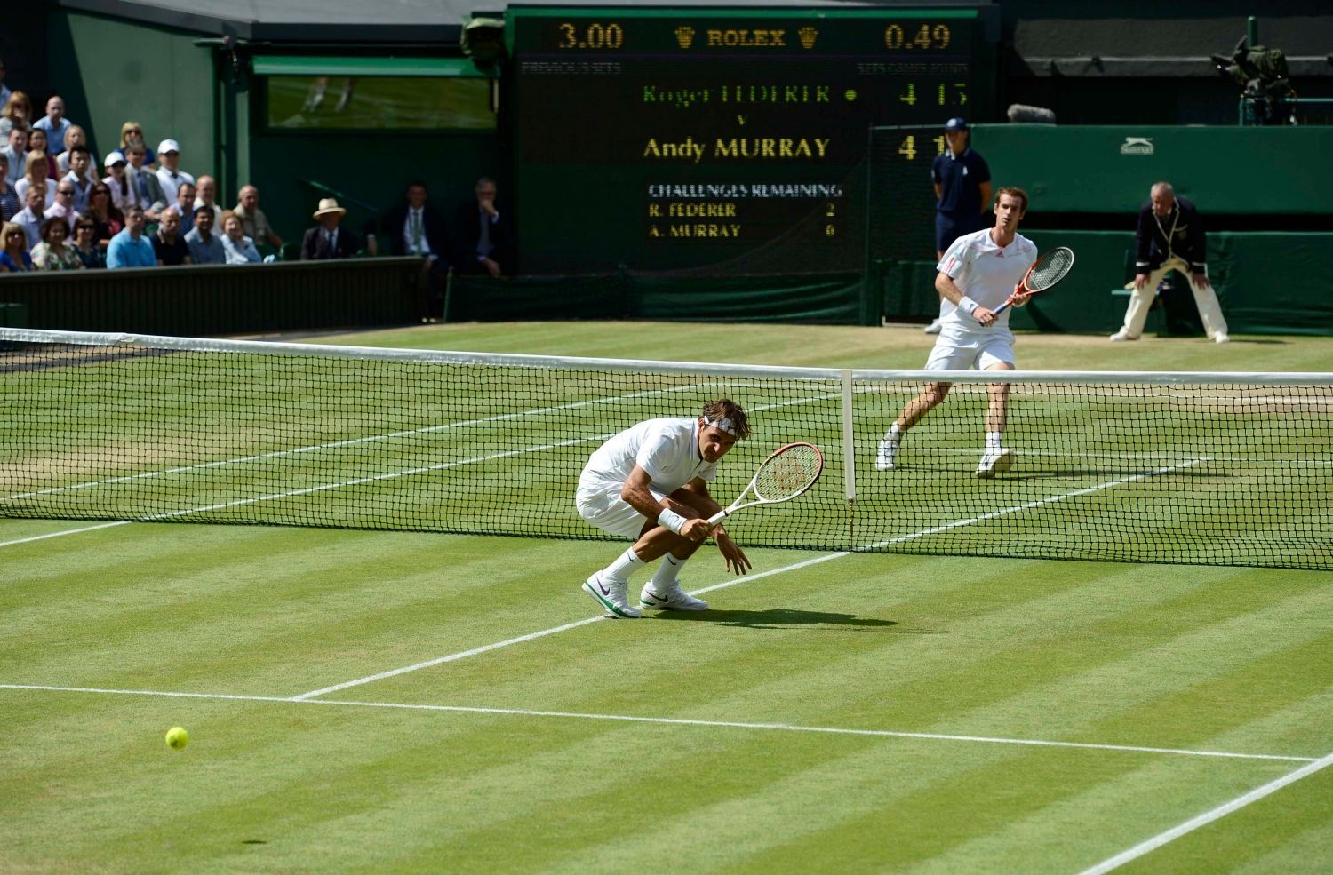 Švýcarský tenista Roger Federer míjí míček během utkání s Britem Andym Murraym ve finále Wimbledonu 2012.