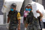 Mexičtí vojáci nesou balíky s rouškami pro Mexiko City. Na prasečí chřipku zahynulo v Mexiku už osmdesát jedna lidí. Světová zdravotnická organizace varuje před pandemií.