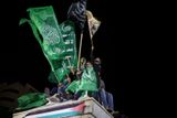 Přívrženci palestinského Hamásu, kteří třímají v ruce vlajku tohoto radikálního hnutí.