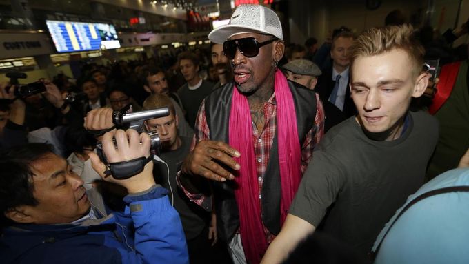 Bývalý basketbalista Dennis Rodman (uprostřed) po příletu na letiště v Pekingu. Odsud zamíří do KLDR. S sebou vzal i další bývalé kolegy z NBA.
