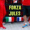Sign in support of Marussia Formula One driver Jules Bianchi of France is seen among members of Ferrari Formula One team before the first Russian Grand Prix in Sochi