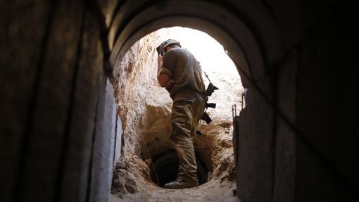 An Israeli soldier looks at a tunnel exposed by the Israeli military, just outside the southern Gaza Strip