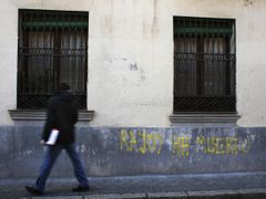 Muž prochází v Madridu kolem nápisu "Rajoy je mrtvý."