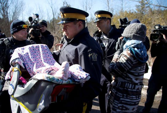 Matku a její dítě odvádí kanadská jízdní policie.