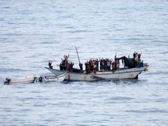 Piráti a rukojmí zvedají ruce předtím, než na palubu lodi vstoupí nizozemské komando