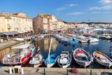 Přístav v Saint-Tropez, to nejsou jen tyto bárky pro rybáře a turisty, ale také honosné jachty boháčů, které jsou vidět v pozadí.