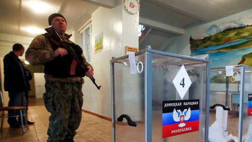 Ozbrojený proruský separatista hlídá volební místnost ve městě Telmanovo v Doněcké oblasti.