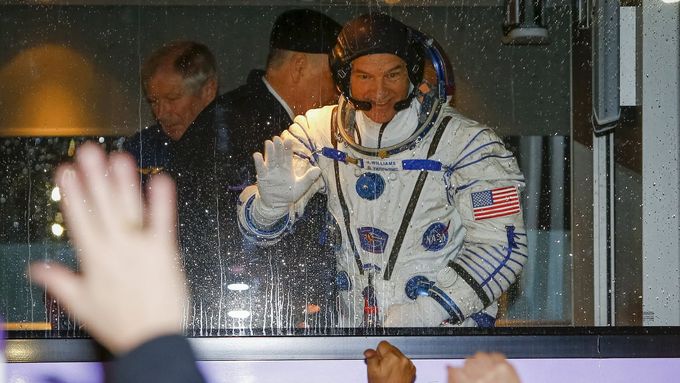 Astronaut Jeff Williams mává z autobusu, jenž posádku dopravil k místu odletu na kosmodromu Bajkonur.