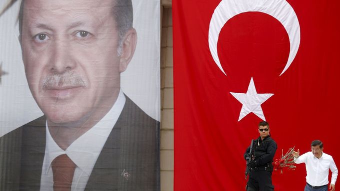 Turecký premiér Davutoglu (AKP) na pódiu s obřím portrétem prezidenta Erdogana.