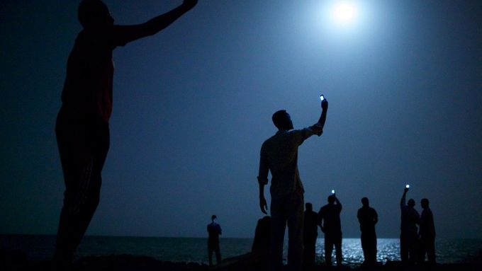 Vítězný snímek soutěže World Press Photo za rok 2013 zachycuje eritrejské uprchlíky, kteří se snaží mobily zachytit signál.