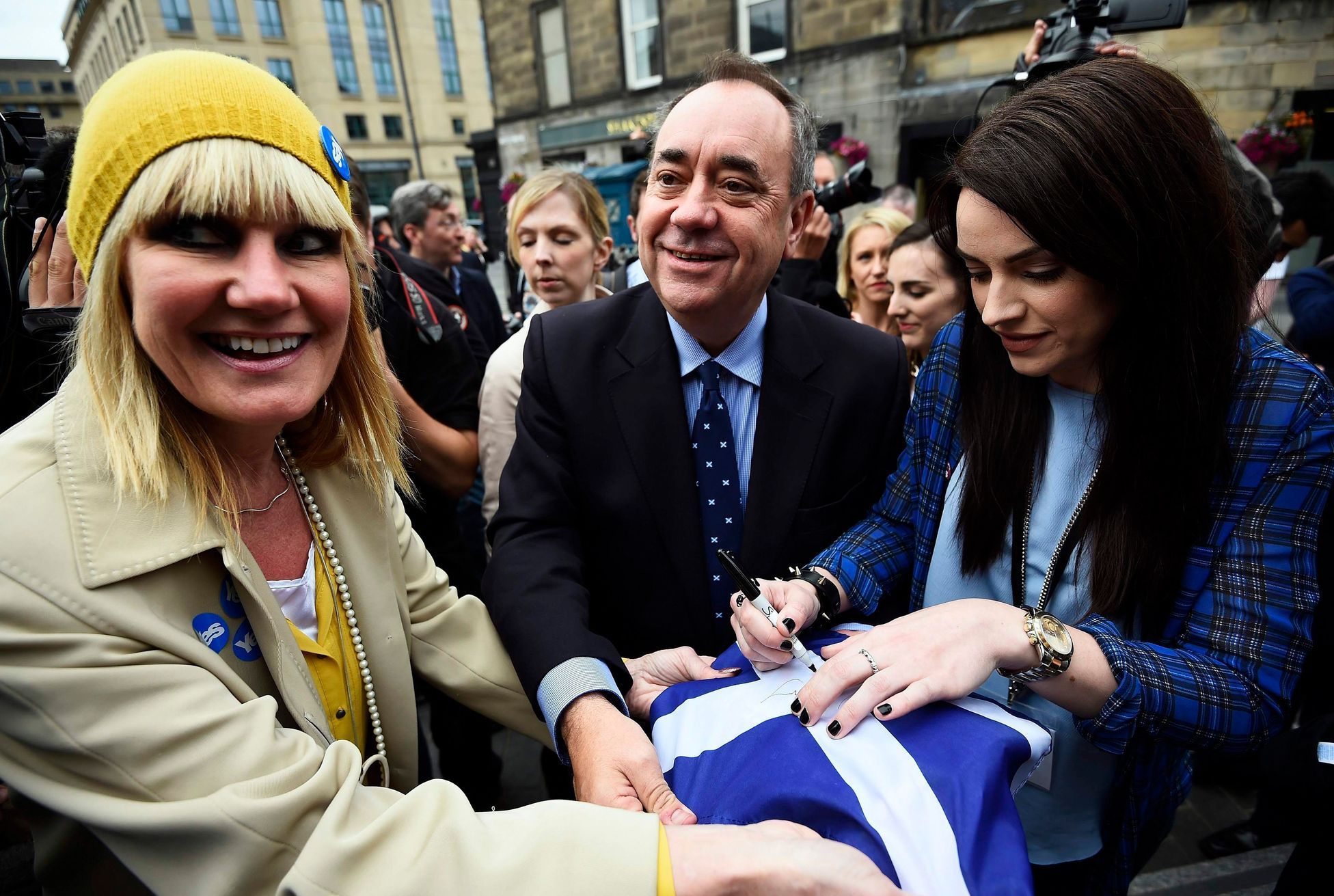 Scotland's First Minister Alex Salmond and local singer-songwriter Amy Macdonald  sign a 'Yes' supporter's flag during an event in Edinburgh, Scotland