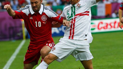 Dennis Rommedahl se snaží projít přes Fabia Coentraa během utkání Dánska s Portugalskem ve skupině B na Euru 2012.