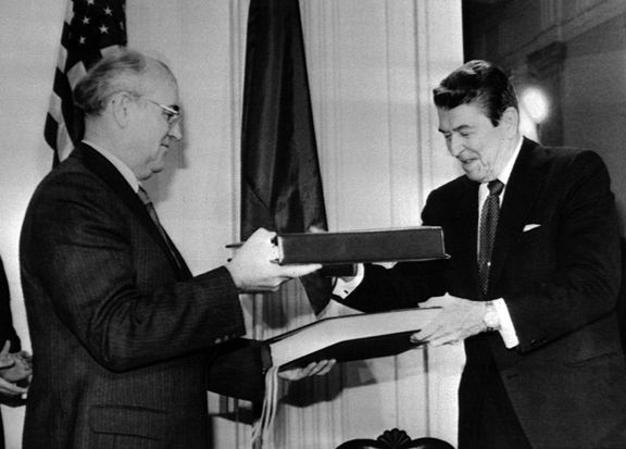 Gorbačov a Reagan si vyměňují dokumenty smlouvy o odstranění sovětských a amerických jaderných raket středního a kratšího doletu, 8. prosince 1987.