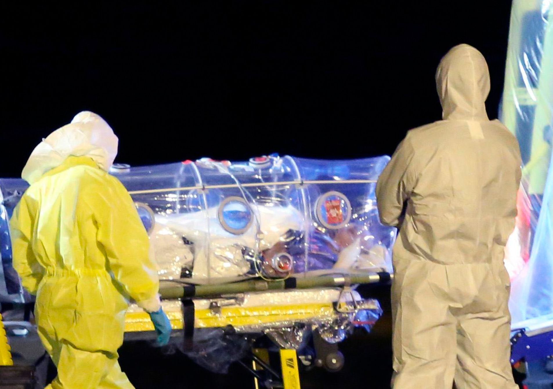 Zdravotníci nakládají španělského kněze nakaženého ebolou do sanitky.