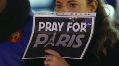 A woman holds a sign during a ceremony in solidarity with the victims the day after a series of deadly attacks in the French capital of Paris, in Lausanne